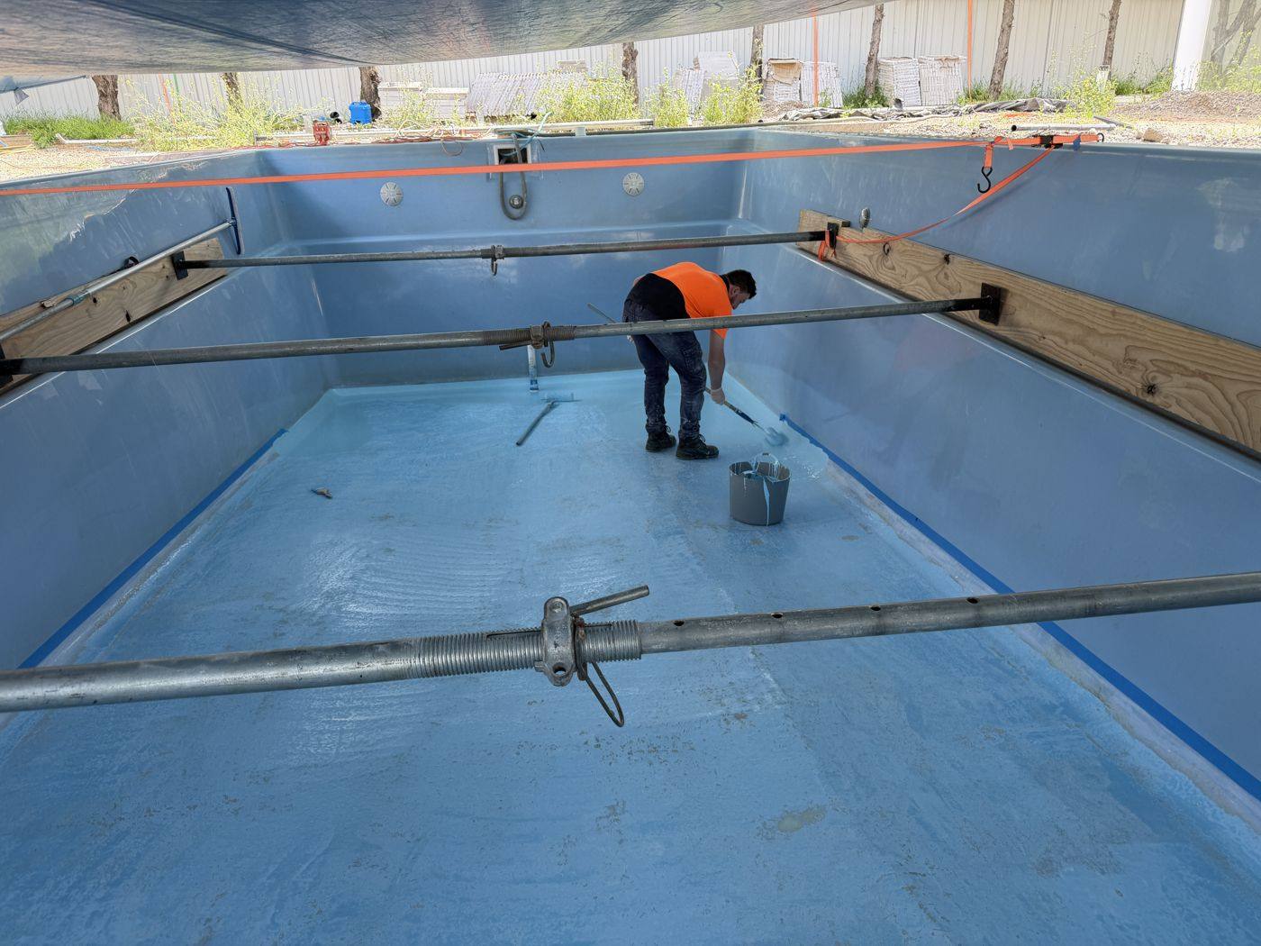 Pool braced with steel props while empty during a resurface