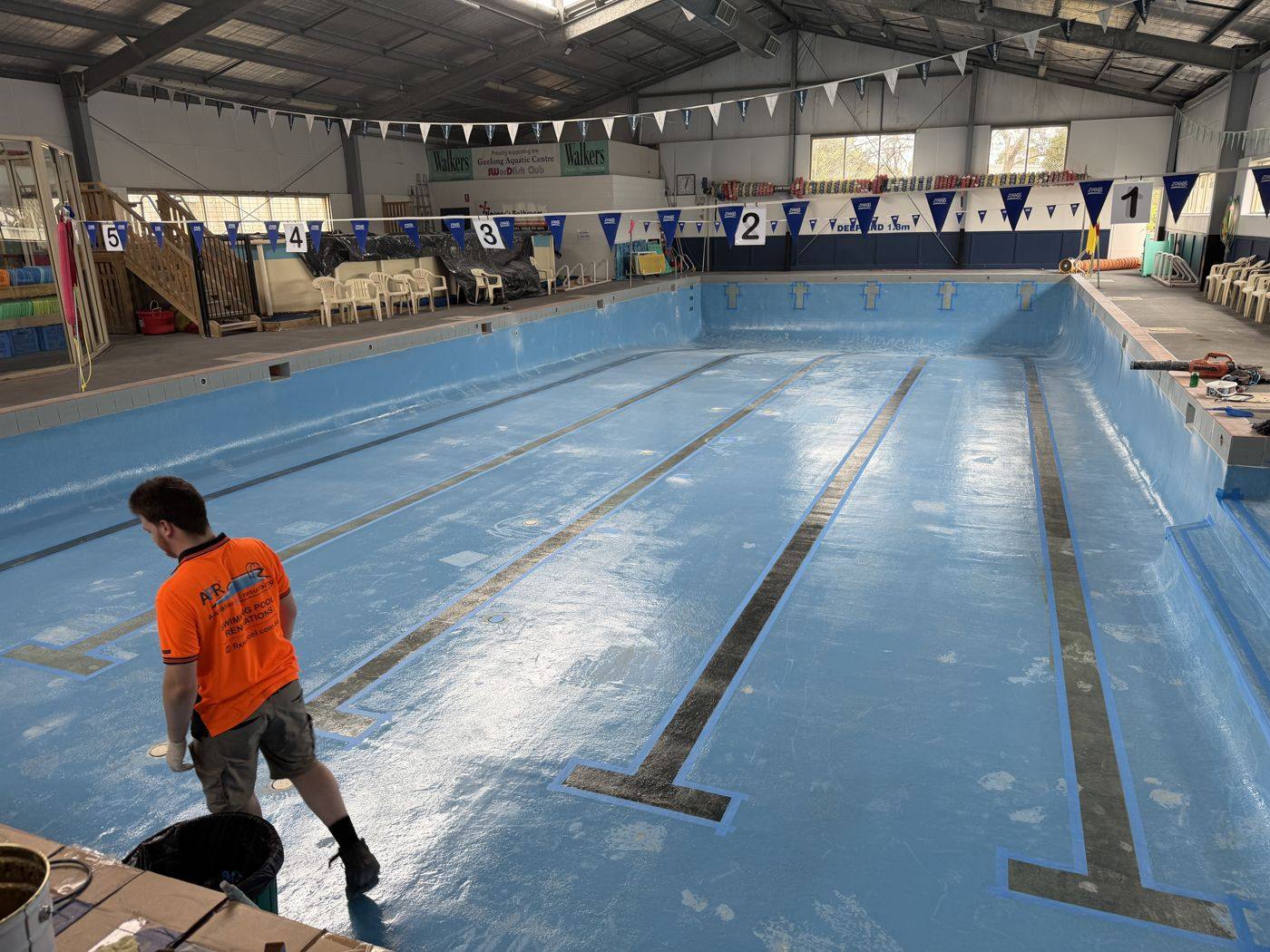 A team member working on a swim school pool during resurfacing