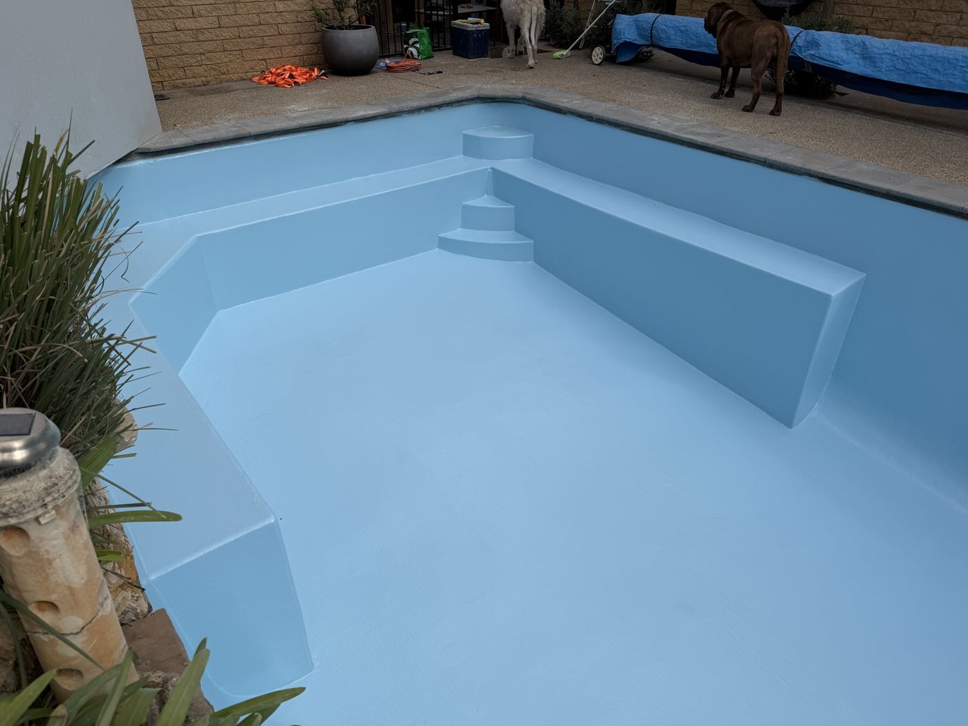 Custom-built steps and ledge finished in light blue gelcoat before filling, in an indoor swim school pool